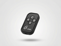 Black remote control with labeled buttons on a light gray background