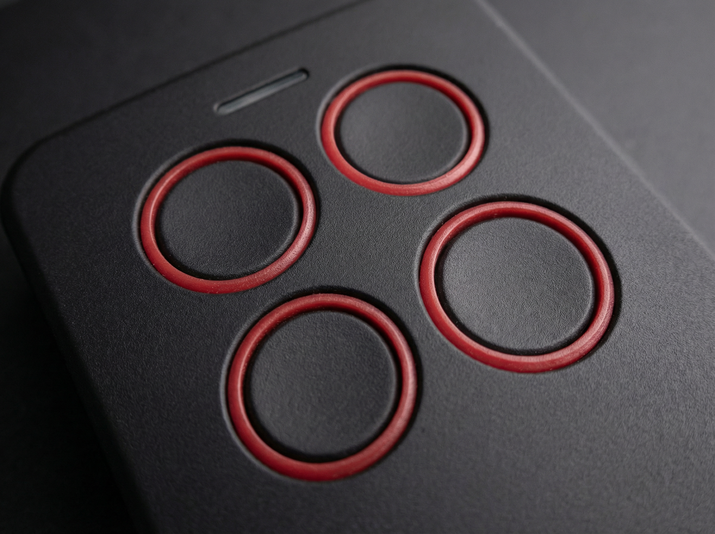 Close-up of a gaming controller with red circular buttons on a dark background