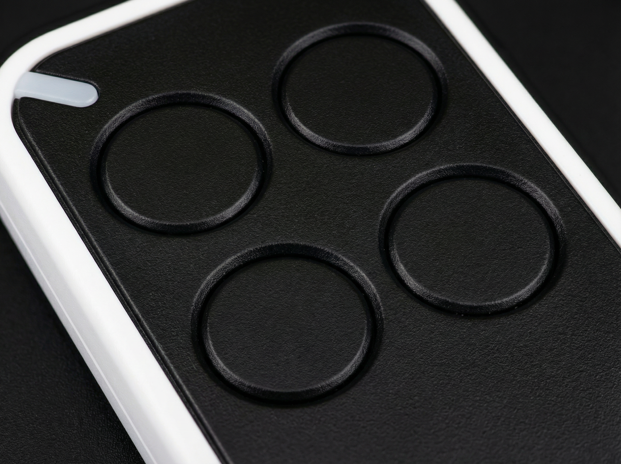 Close-up of a black phone case with circular cutouts on a dark background