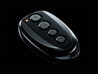 Black remote control with four buttons on a black background